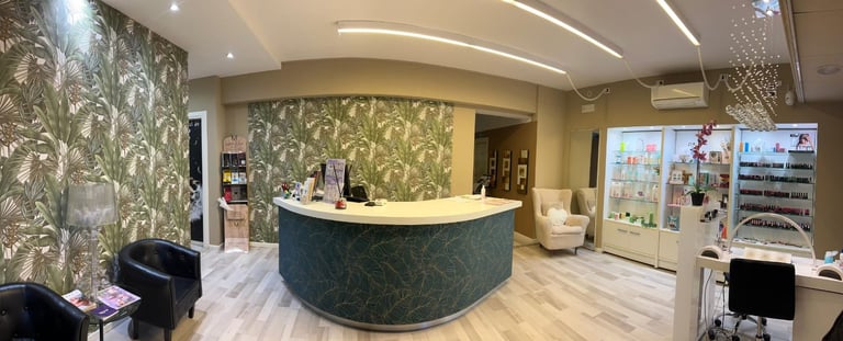 Modern office reception area with curved green marble desk, botanical wallpaper, ambient lighting, and waiting area seating