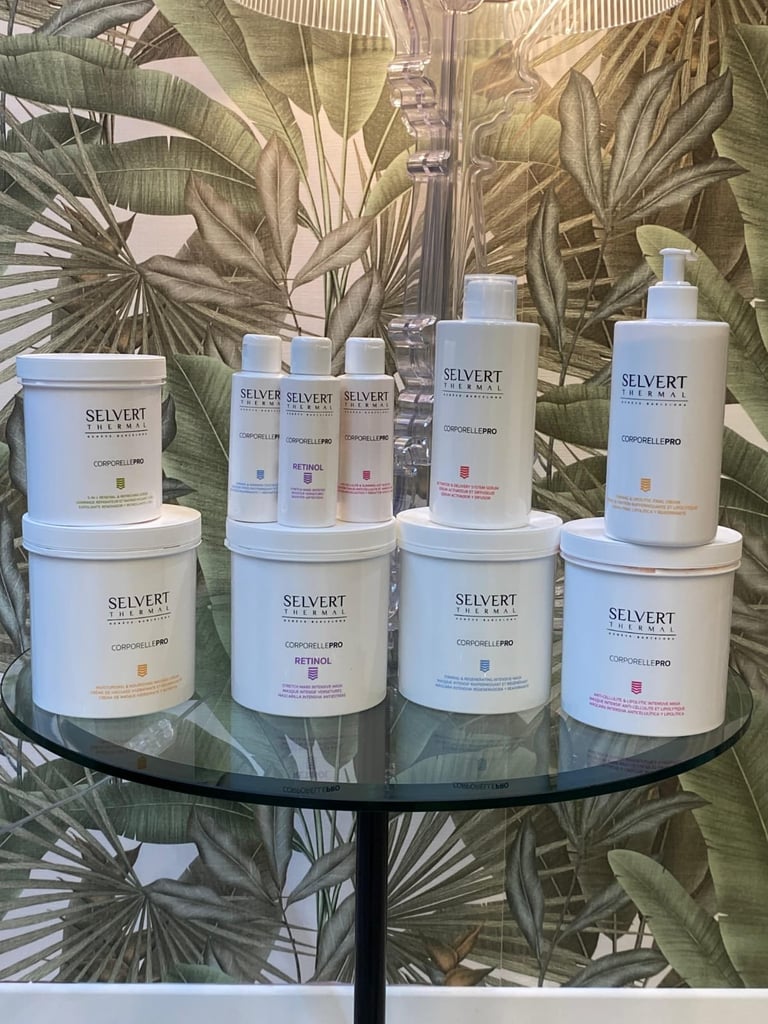 Collection of Selvert skincare products displayed on a round glass table against a botanical leaf wallpaper backdrop